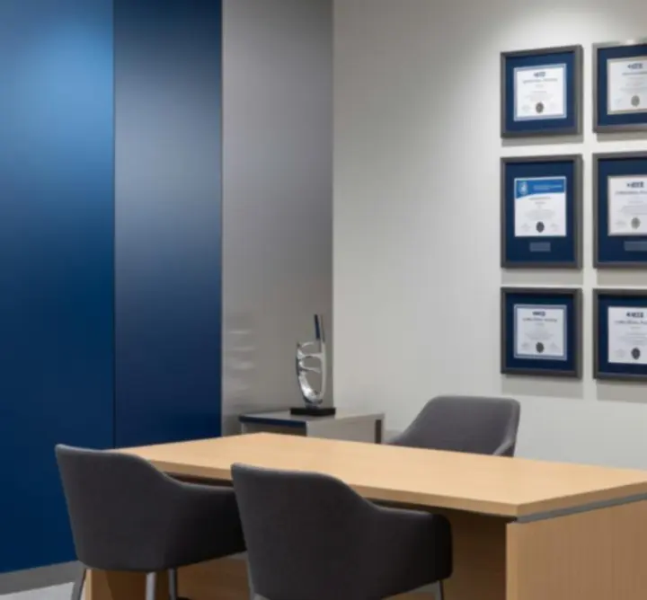 Framed electrical and safety certifications displayed in a modern office