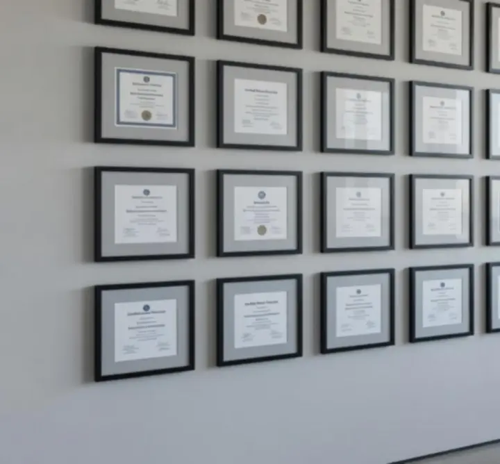 Framed electrical and safety certifications displayed on a modern office wall
